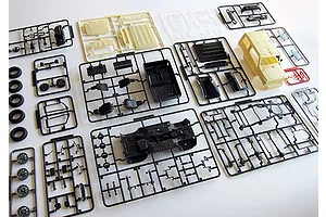 Multiple plastic model kit sprues for a 1/24 scale Suzuki Jimny, including body panels, chassis, wheels, and interior parts on a white background.