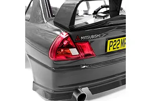 Close-up of the rear of a silver 1/10 scale Mitsubishi Lancer Evo IV RC body shell featuring a rear spoiler, tail lights, and a yellow license plate.