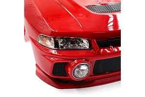 Close-up of the front passenger side of a red Mitsubishi Lancer Evo IV RC car body shell, showing the headlight, fog light, and grille details.