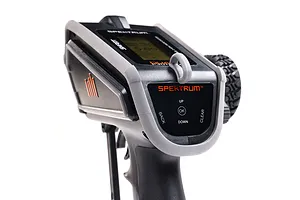 Close-up of the top control panel of a Spektrum DX Rugged RC transmitter featuring a grey protective bumper, LCD screen, and navigation buttons.
