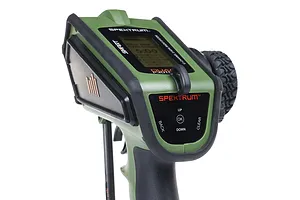Close-up of the Spektrum DX Rugged green RC transmitter showing the top control panel, display, and steering wheel.