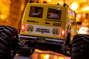Rear view of the yellow Kyosho Fazer Mk2 Mad Van RC monster truck with Mooneyes branding and illuminated tail lights.