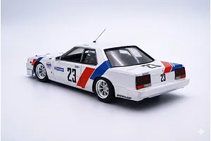A 1/24 scale model of a 1986 Nissan Skyline RS Turbo race car, featuring a white body with red and blue racing stripes and the number 23.