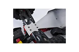 A silver stainless steel skid plate installed on the underside of an RC vehicle chassis, showing mounting screws and surrounding suspension components.
