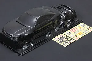 A carbon fiber patterned 1/10 scale RC Nissan S15 Silvia body shell with included decal sheets on a dark background.