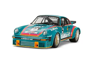 A studio shot of a 1/24 scale Tamiya Porsche 934 Turbo RSR Vaillant model car in teal with orange and pink racing stripes and Vaillant branding.