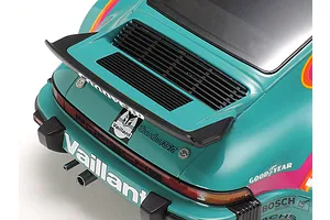 Close-up of the rear section of a Tamiya 1/24 scale Porsche 934 Turbo RSR Vaillant model car, showing the spoiler, engine grille, and racing decals.