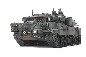 Rear view of a Tamiya 1/48 scale Leopard 2 A7V model tank featuring camouflage paint, a tank commander figure, and detailed rear hull components.