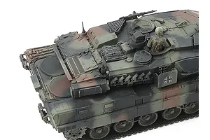 High-angle view of a Tamiya 1/48 scale Leopard 2 A7V tank model showing the turret, engine deck, and a crew member figure.