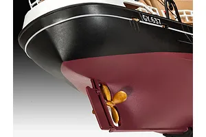 Close-up of the stern of a model fishing trawler, showing the hull, rudder, and gold-colored propeller.