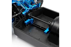 Close-up of blue anodized aluminium servo mounts installed on a black RC car chassis.