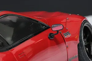 Close-up of a black side mirror mounted on a red 1/10 scale RC car body shell.