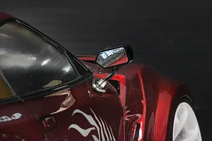 Close-up of a Pandora RC S-GT-F1 style side mirror mounted on a metallic red RC drift car body shell.