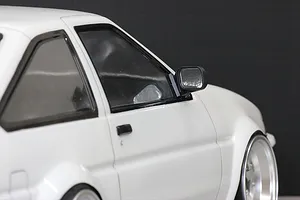 Close-up of a white RC car body shell featuring a black side mirror mounted on the door.