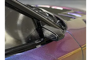 Close-up of a carbon-style aero door mirror mounted on a purple RC car body shell.