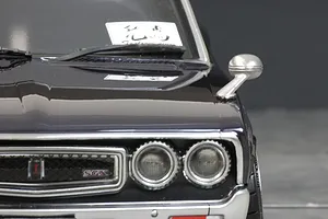 Close-up of a silver fender mirror mounted on the hood of a dark-colored 1/10 scale RC car body shell.
