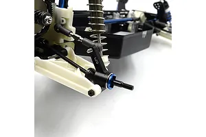 A close-up of a black aluminium RC rear hub installed on a white plastic suspension arm of an RC car chassis.