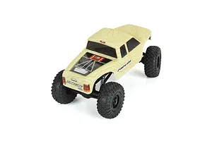 Pro-Line Coyote body shell in tan topographical print mounted on a small RC crawler chassis, viewed from a high angle.