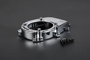 A chrome-plated Rovan engine cover for an RC car, shown with a set of small black mounting screws on a dark grey background.