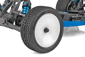 Close-up of the front wheel and suspension of a Team Associated RC buggy, featuring a white dish wheel, knobby rubber tire, and blue anodized shock absorber.