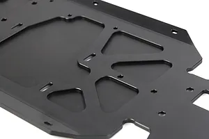 A close-up view of a black anodized aluminium RC car main chassis plate with various mounting holes and cutouts.