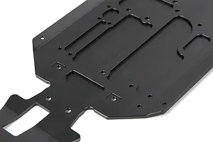 A black anodized aluminium main chassis plate for an RC vehicle, featuring various mounting holes and milled cutouts.