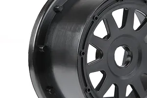 A close-up view of a black plastic RC car wheel rim, showing the multi-spoke design and outer beadlock-style mounting points.