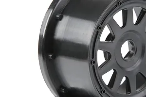 A close-up side view of a black 1/5 scale RC short course truck rear wheel rim on a white background.