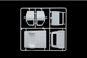 A white plastic sprue containing various vehicle body parts for a 1/24 scale model kit, including doors and floor panels, against a black background.