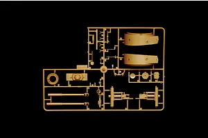 A tan plastic sprue containing various model tank parts, including turret sections and gun barrels, against a black background.