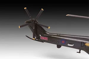 Close-up of the tail section of a 1/144 scale Westland Puma HC.1 plastic model helicopter, showing the tail rotor, markings, and dark green finish.