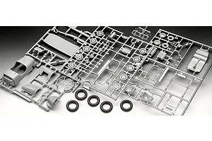 Unassembled plastic model kit parts for an Aston Martin Ulster on grey sprues with four black rubber tires.