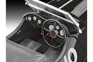 Close-up of the detailed interior cockpit of a 1/32 scale Jaguar SS 100 plastic model car, showing the steering wheel, dashboard gauges, and seats.