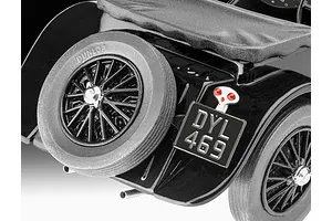 Close-up of the rear section of a black Jaguar SS 100 model car, showing the spare tire, license plate DYL 469, and red taillight.