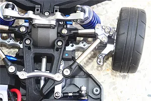 Close-up of the front suspension and steering assembly of an RC car featuring titanium tie rods and blue aluminium components.