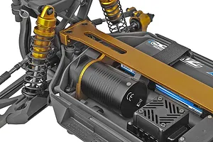 Close-up of the chassis of a Team Associated Rival MT10 RC monster truck, showing the motor, gold-anodized shock absorbers, and battery strap.