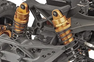 Close-up of the gold-anodized shock absorbers and black plastic suspension components on a Team Associated Rival MT10 RC monster truck.
