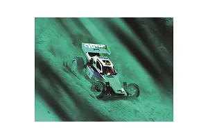 Kyosho Tomahawk '85 WC Worlds Spec RC buggy driving on a dirt track with a green-tinted motion blur effect.
