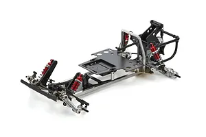 A partially assembled Kyosho Tomahawk 1/10 scale RC buggy chassis featuring a metal frame, black battery tray, and red coil-over shock absorbers.