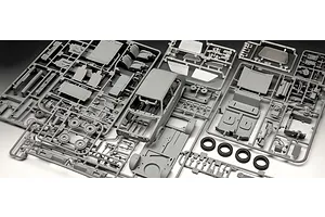 Plastic model kit sprues for a 1/24 scale 1983 VW Golf GTI, including car body, interior parts, and rubber tires.