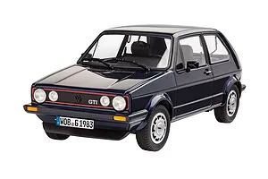 A 1/24 scale plastic model of a dark blue 1983 VW Golf GTI Pirelli edition, featuring detailed wheels, headlights, and a German license plate.
