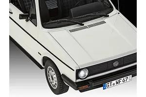 A high-angle close-up of a white 1/24 scale model VW Golf 1, showing the front hood, grille, headlights, and license plate.