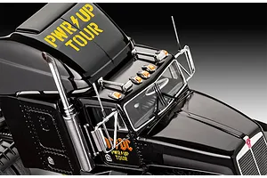 Close-up of the cab of a black Revell AC/DC Power Up Tour model truck with yellow branding and chrome details.