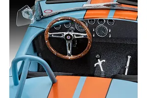 Close-up of the detailed interior of a 1/24 scale Shelby Cobra model car, showing the dashboard, steering wheel, and gear shifter.