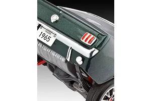 Close-up of the rear end of a dark green 1965 Ford Mustang model car, showing the taillight, Texas license plate, and rear chassis details.