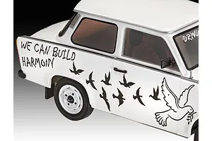 A close-up of a white 1/24 scale Trabant 601S model car featuring black decals of birds and the text WE CAN BUILD HARMONY on the side panel.