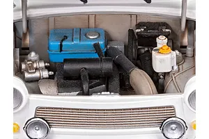 Close-up of the detailed engine bay of a 1/24 scale Trabant 601S model car, showing a blue fuel tank, black engine components, and white bodywork.