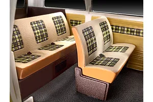 Interior view of a Revell 1/24 scale VW T3 model bus showing beige and brown bench seats with green and black plaid fabric patterns.