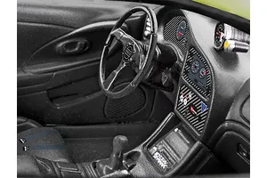 Close-up of the detailed black interior of a 1/25 scale model Mitsubishi Eclipse, featuring a steering wheel, dashboard gauges, and center console.