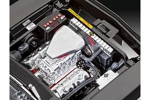 Close-up of the detailed engine bay of a 1/25 scale Revell 1970 Dodge Charger model kit, featuring a chrome supercharger and Mopar battery.